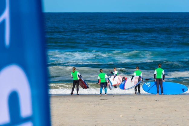 Trainer Hannes begleitet die Camp-Teilnehmer in die Welle